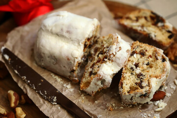 Christmas stollen cut into pieces on a wooden board.
