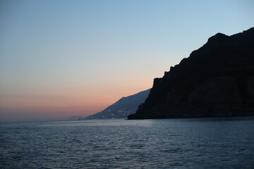 Sunset view of the sea and mountain. Scenic view of the coast of island of the region. Evening landscape with mountains and sea. Dusk time lapse. Seascape with blue sky and clouds. Sea and rocks