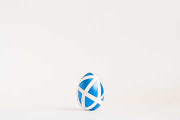 Easter golden decorated egg with geometric pattern isolated on white background. Minimal easter concept. Happy Easter card with copy space for text Top view, flatlay. 