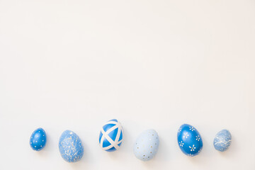 Blue Easter decorated eggs isolated on white background. Minimal easter concept. Happy Easter card with copy space for text. Top view, flatlay.