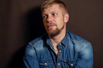 close-up portrait of a man. a man with a beard. man in blue denim shirt