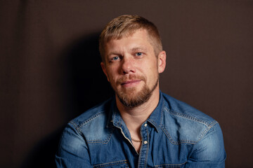 close-up portrait of a man. a man with a beard. man in blue denim shirt