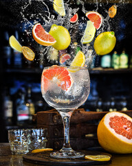 Imagen publicitaria de splash de un Trago gin tonic en un bar. Cocktail cítrico por la noche