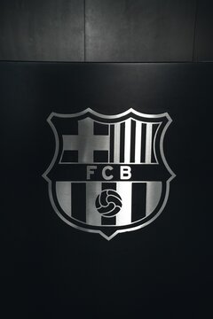 Vertical closeup of the logo of FC Barcelona on a black background in Camp Nou