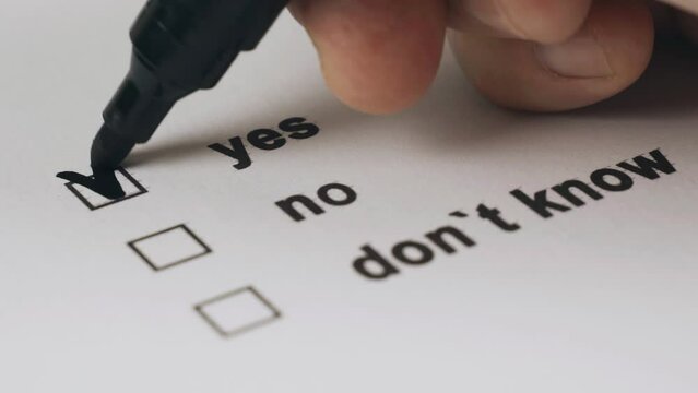The person marks the item yes in the list of suggested items with a marker. Close-up. Choice concept.