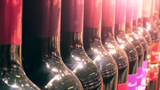 Red wine bottles line up on the shelf of a liquor store (ABC store) or supermarket. Close up shot