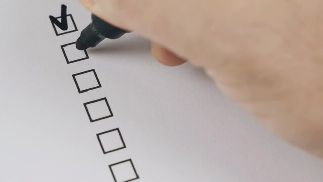 A person ticks off items on a list on paper. Close-up.