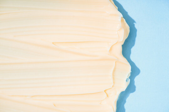 Silky cream texture over blue as background with copy space. Vanilla cosmetic cream smears. Skincare product