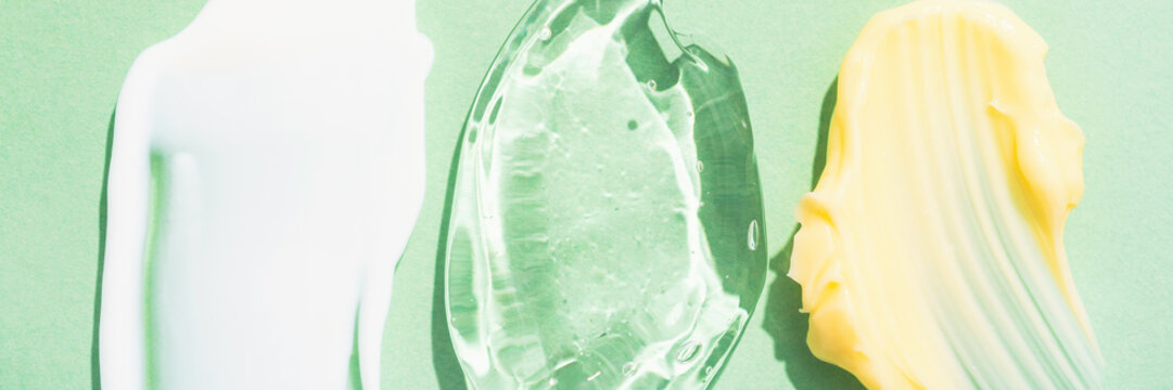 Banner with cream and gel smears, various cosmetic products texture. Cream and gel smudges over green background. Skincare and beauty product