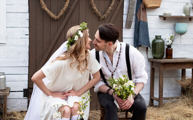 country bride in a white short dress and groom in a white shirt in the village wedding, boho style.