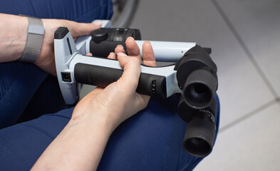 The doctor holds a portable slit lamp in one hand. Ophthalmologist getting ready accepted patient...