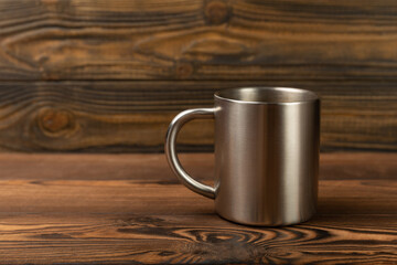 Metal travel mug on a brown background. Mug for hot drinks. place for text. copy space.