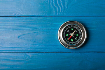 Classic round compass on blue texture background. Symbol of tourism with a compass, travel with a...