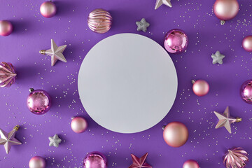Christmas holiday concept. Flat lay composition of pink balls, stars and sequins on violet...
