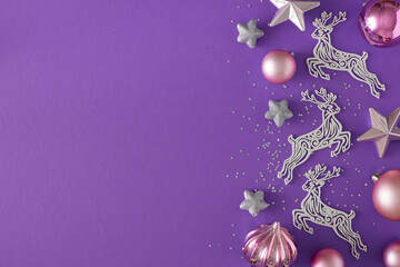 Obraz na płótnie Canvas New Year eve concept. Flat lay composition of silver deer, pink baubles, stars and sequins on violet background with copy space. Creative holiday card idea.