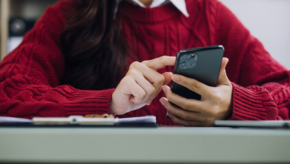 Woman hand using smart phone and laptop in outdoor nature park and sunset sky with bokeh light abstract background. Technology business and freelance working concept. Vintage tone filter color style.