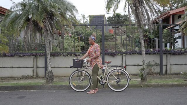 Mujer afro caribe&ntilde;a en bicicleta se detiene para ofrecer a clientes en la calle los productos que vende  