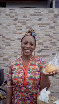 Retrato vertical en video de una hermosa mujer latina afro caribe&ntilde;a muy sonriente viendo a c&aacute;mara y vendiendo sus productos del caribe