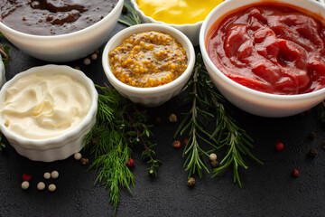 Different types of sauces in bowls with seasonings, rosemary and dill, thyme and and peppercorns