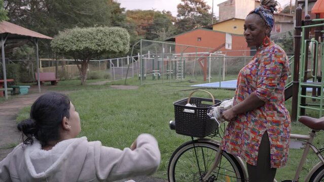 Video de una mujer afro caribe&ntilde;a vendiendo sus productos a una mujer sentada en un parque de su comunidad