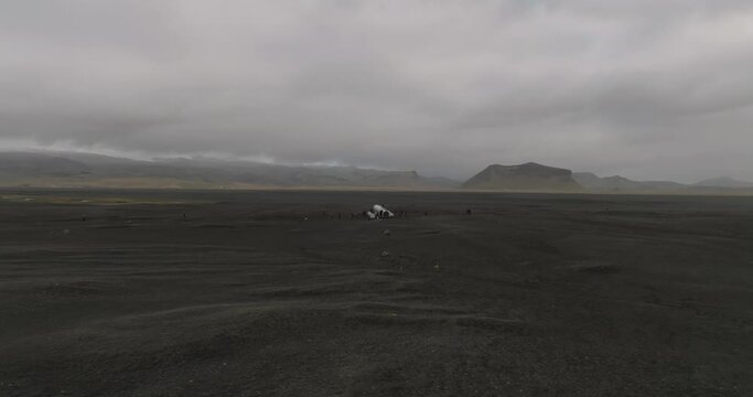 aerial orbit shot of dc 3 plane wreck in iceland black beach with mountains on background iceland