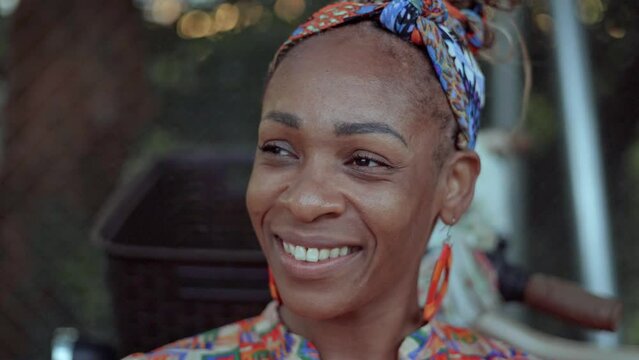 Retrato en video de una hermosa mujer afro caribe&ntilde;a muy sonriente con una pa&ntilde;oleta en su cabeza vuelve a ver a c&aacute;mara 