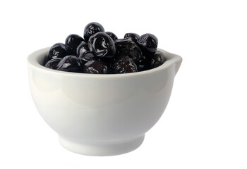 black olives in a white porcelain bowl, isolated on white background