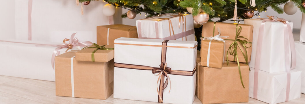 Craft gifts under the tree. The concept of Christmas and New Year.Christmas mood. Celebrating of New Year.Many boxes of Christmas gifts in eco-friendly craft paper packaging. web banner
