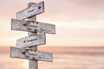 clear concise complete correct text written on wooden signpost outdoors at the beach during sunset - 548043448