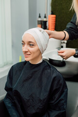 A woman with a towel on head. Hair washing, treatment in the hairdressing salon
