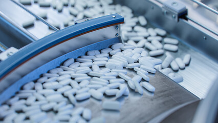 Tablets and Capsules Manufacturing Process. Close-up Shot of Medical Drug Production Line. White...