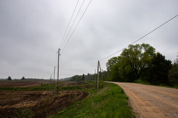 Fototapeta na wymiar winding country road, electric transmission lines along the road