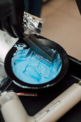 A professional hairdresser mixes a dye with an oxidizer. Hair coloring