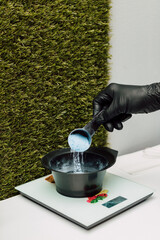 A hairdresser pours an oxidizer. The process of preparation before coloring hair