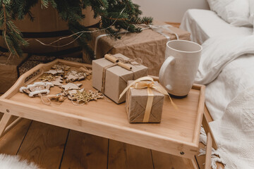 New 2023 2024 year christmas. room ohouse beige shades decorated for holidays. Lots of gifts under Christmas tree and light bulbs. beige tray with New Year's sweets atmosphere of holiday home comfort