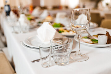 elegant dinner table setting in restaurant or hotel with wine glasses