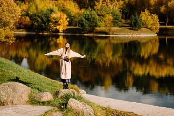 young beautiful girl is resting in nature. woman walking in the park on sunny autumn day