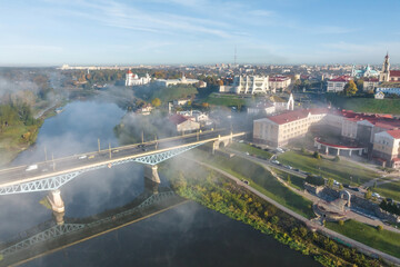 earlier foggy morning and aerial panoramic view on medieval castle and promenade overlooking the old city and historic buildings near wide river