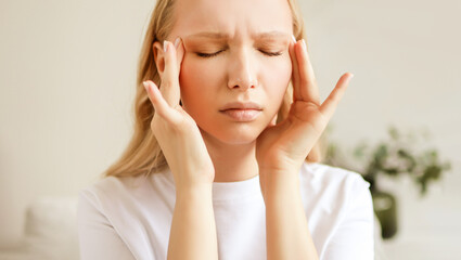 Stressed unhealthy woman feeling tired have terrible strong headache pain. Female suffering from...
