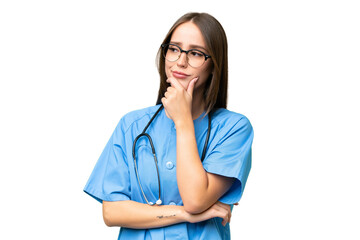 Young nurse caucasian woman over isolated background having doubts and with confuse face expression - Powered by Adobe