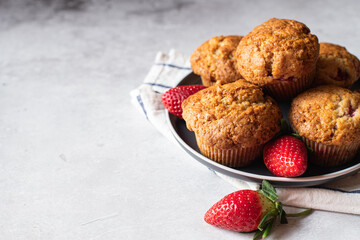 Strawberry muffins with berries served on a plate on a white marble background. - 548052657