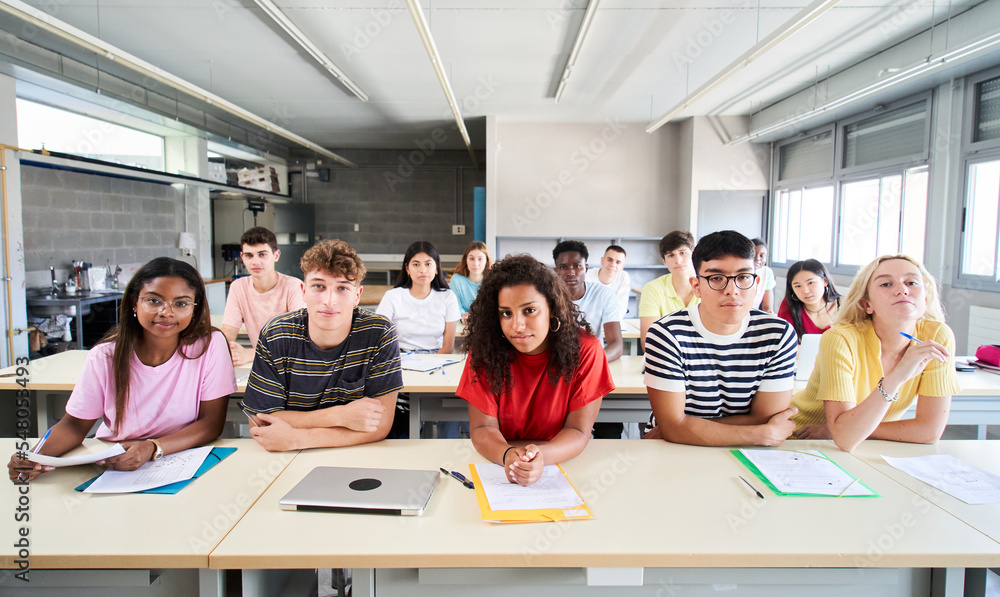 Wall mural Confident group of university college sitting at classroom looking at camera with serious face. Portrait of Students of high school study together. People, education and community people. High quality