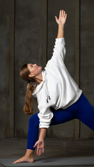 The athlete stands in the triangle pose. Pilates and yoga training. 