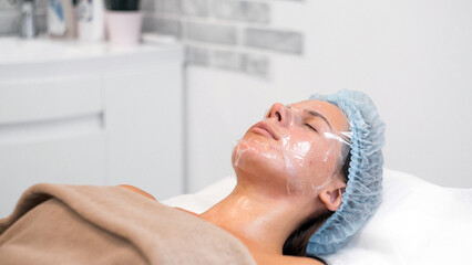 Obraz na płótnie Canvas Portrait applying mask on client's face in spa salon. Wellness center. Healthcare occupation