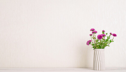 Garden chrysanthemum in concrete vase on white wooden desktop with copy space.