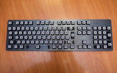 Disassembled black computer keyboard without buttons.