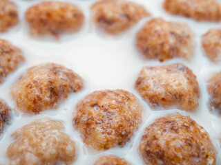 Swollen corn balls in milk close-up. Selective focus. Healthy breakfast of corn flakes and milk.