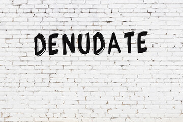 White wall with black paint inscription denudate on it
