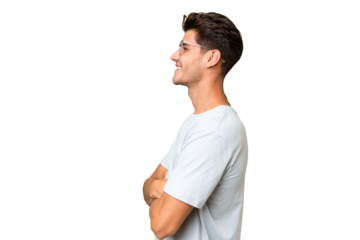 Young caucasian handsome man over isolated background in lateral position