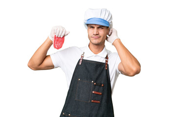 Butcher caucasian man wearing an apron and serving fresh cut meat over isolated background having doubts